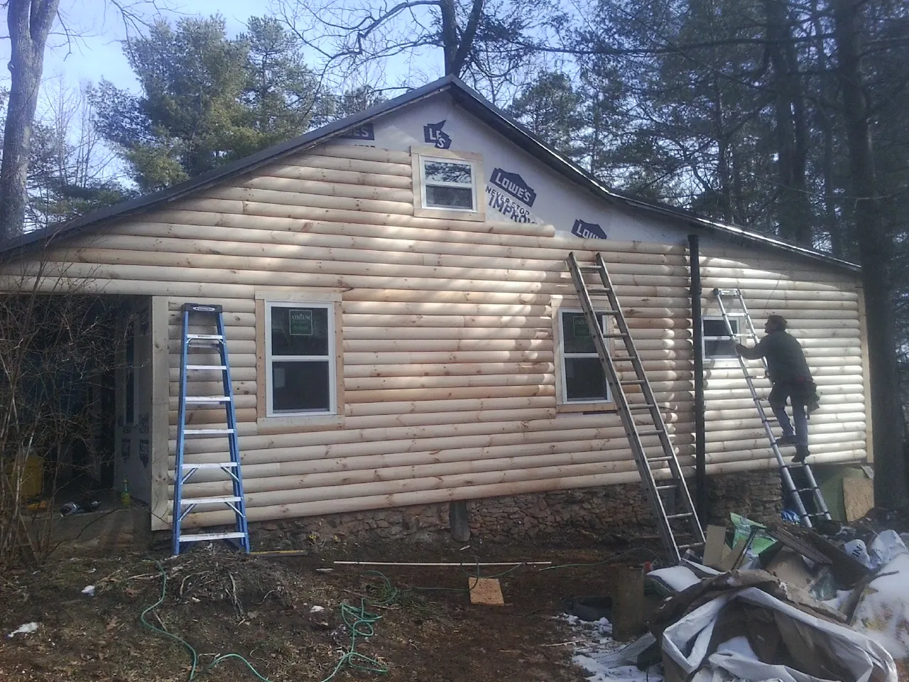 Ladders set against fresh log siding during an exterior remodel in Waynesburg